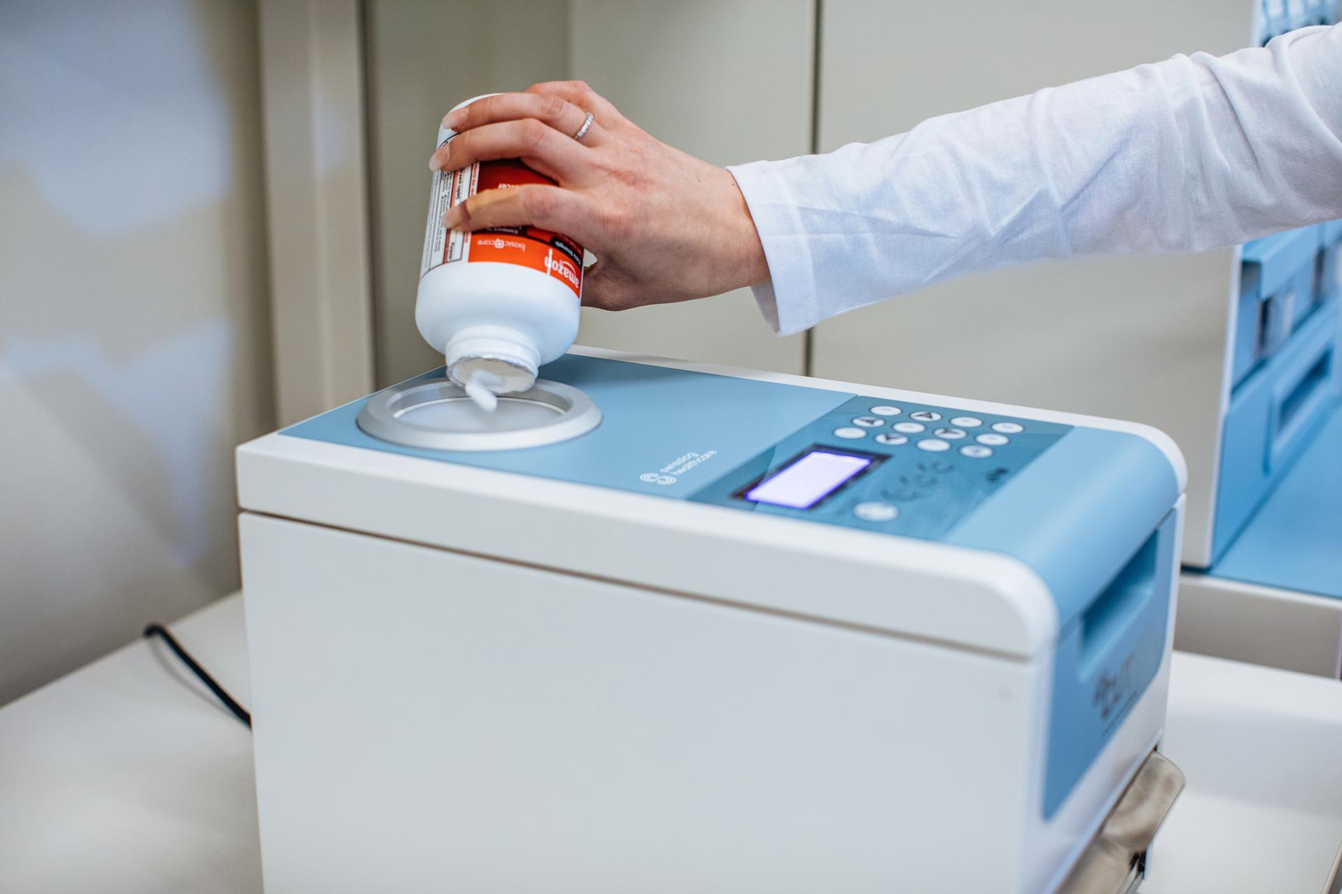 user pouring pills into automated pill cutter